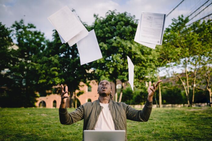 pexels-photo-4560150 graduate with papers and laptop excited about getting job