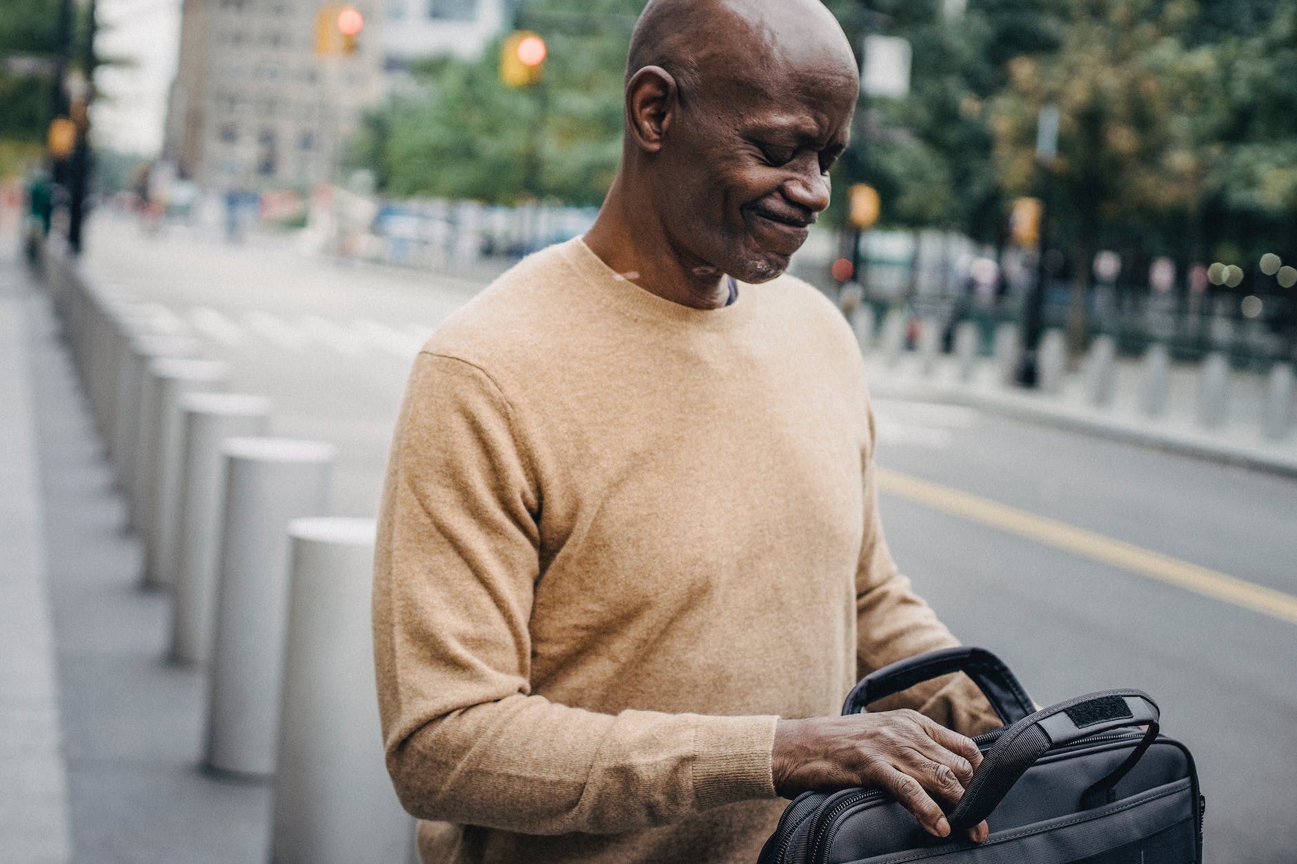 Upset man opening case bag in downtown (shows importance of Emotional Well-being during Job Search)