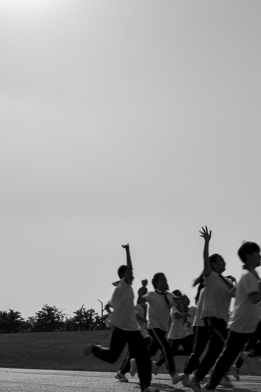 a grayscale of children running to show youth empowerment through sports