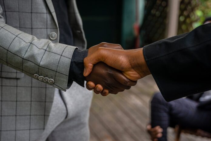 pexels-photo-8276364 men in suit jackets shaking hands